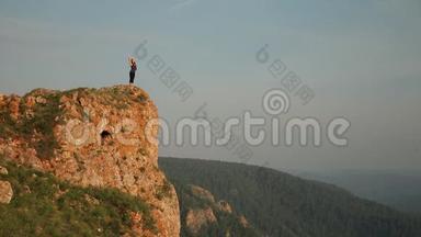 一个年轻的女人站在山顶上。